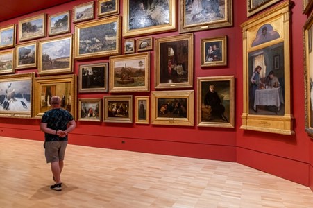 美術館で絵画を見る男性